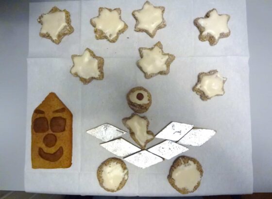 Biscuits au pain d'épice avec glaçage et étoiles sur un morceau de papier.