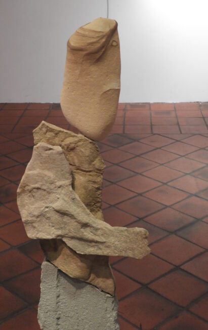 Une sculpture représentant un homme assis sur un rocher.