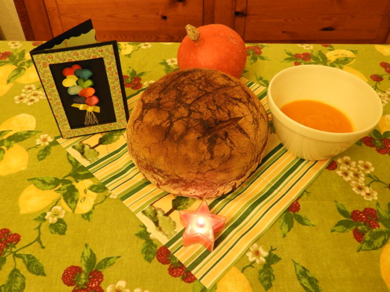 Une miche de pain et une bougie sur une table.