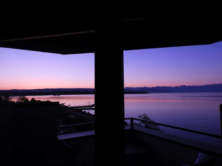 Une vue sur un lac et des montagnes depuis un balcon.