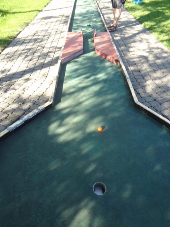 Un homme joue au minigolf dans un parc.