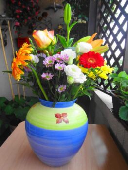 Un artiste peintre avec un vase de fleurs sur une table.