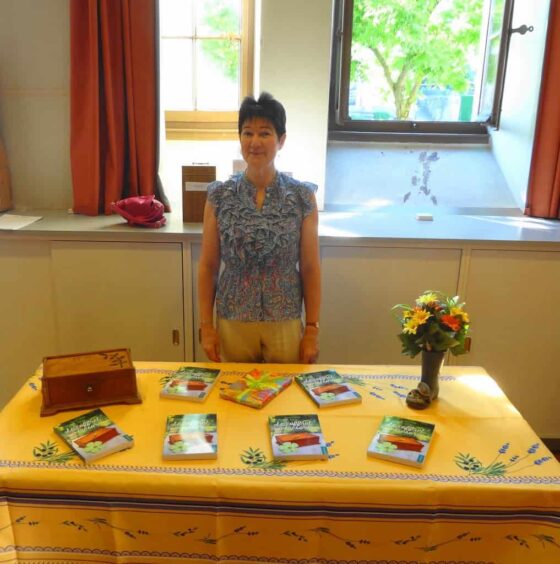 Une femme présentant des livres dans la salle Fletcher à Lausanne.