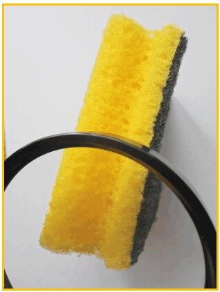Une éponge jaune avec un manche noir.