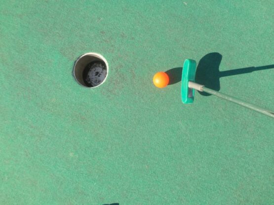 Une balle de golf dans un trou sur un parcours de golf vert.