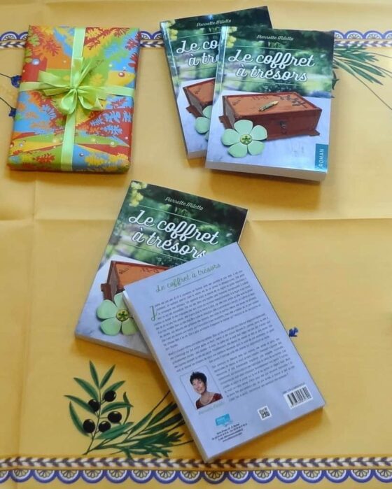 Trois livres sur une table avec une nappe jaune.