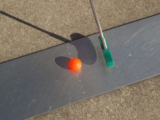 Une balle de golf est posée sur une surface métallique.